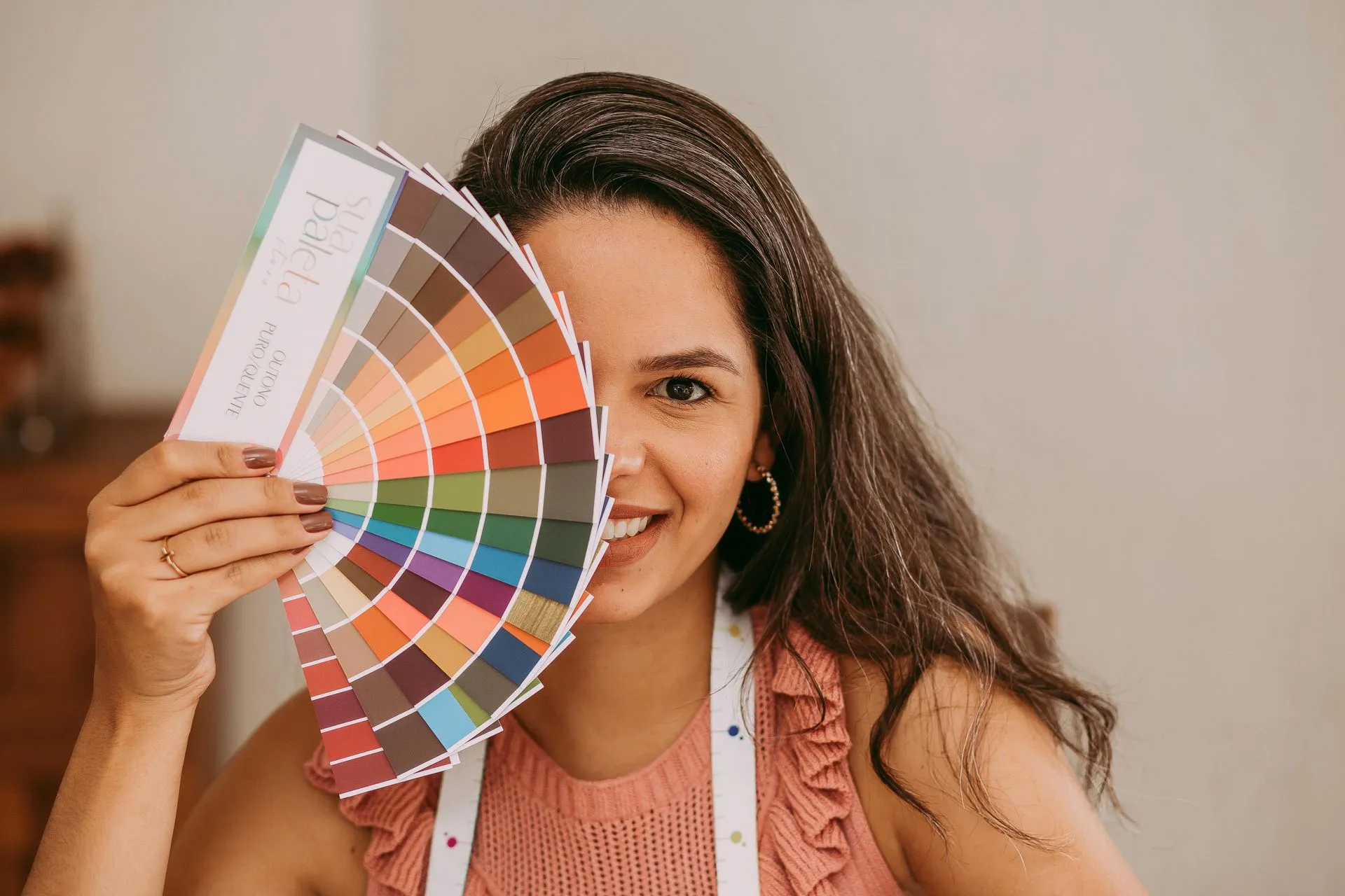 woman displaying various color swatches in front of her face
